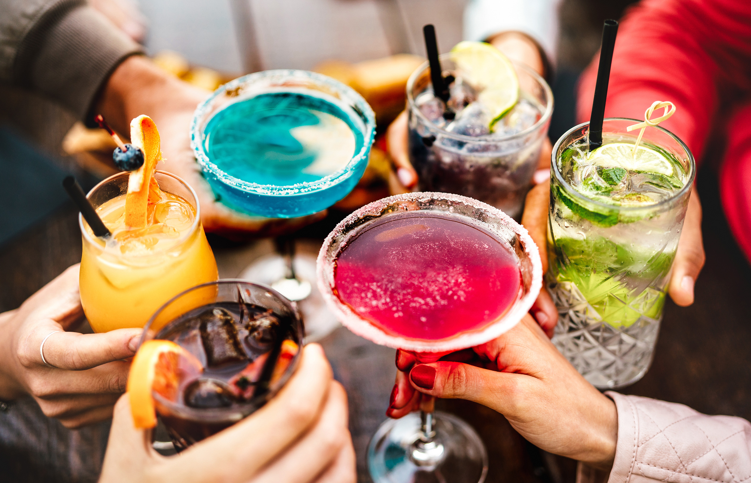Hero image close-up of toast with variety of tropical drinks